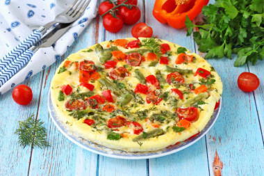 Омлет с овощами сыром и зеленью на сковороде
