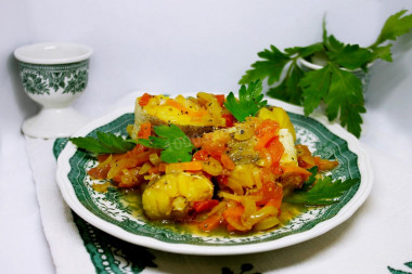 Хек тушёный с луком, морковью и овощами на сковороде